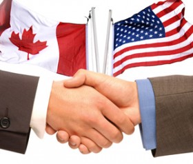 Shaking hands, Canada and U.S. Flags
